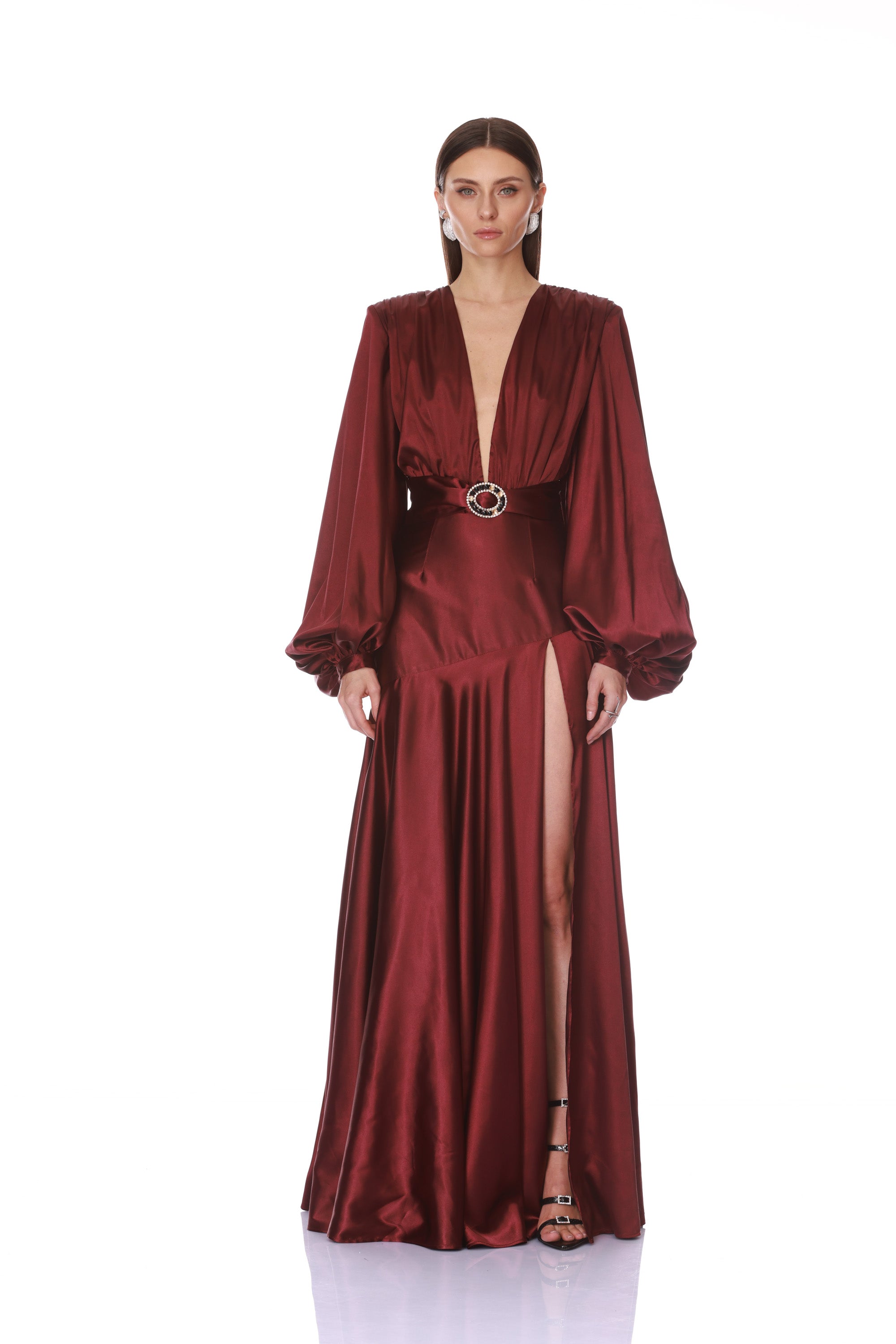 Maroon evening gown with long sleeves and a belt on a white background